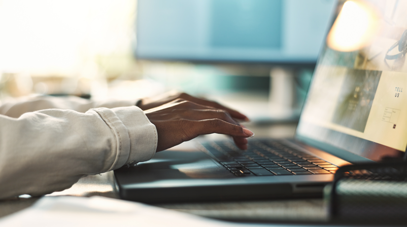 Person using a laptop to research brand information and digital content online.