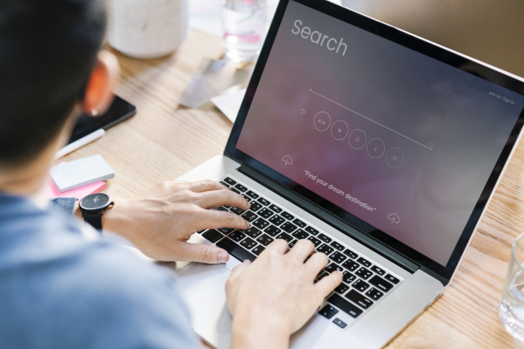 Hands typing on a laptop using an AI search tool, representing digital strategies from a life science marketing agency.